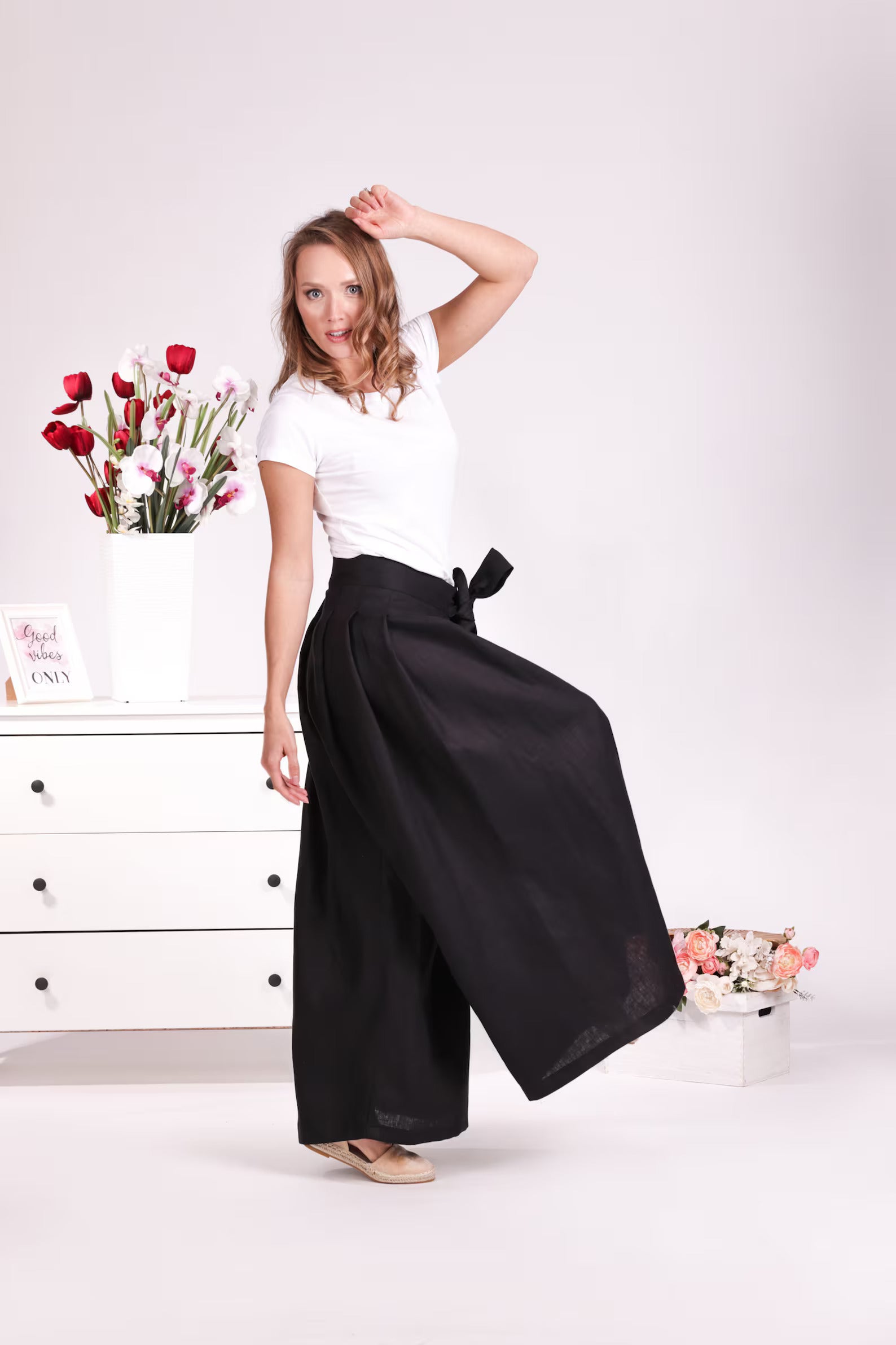Side view of Relaxed black linen trousers with bow detail