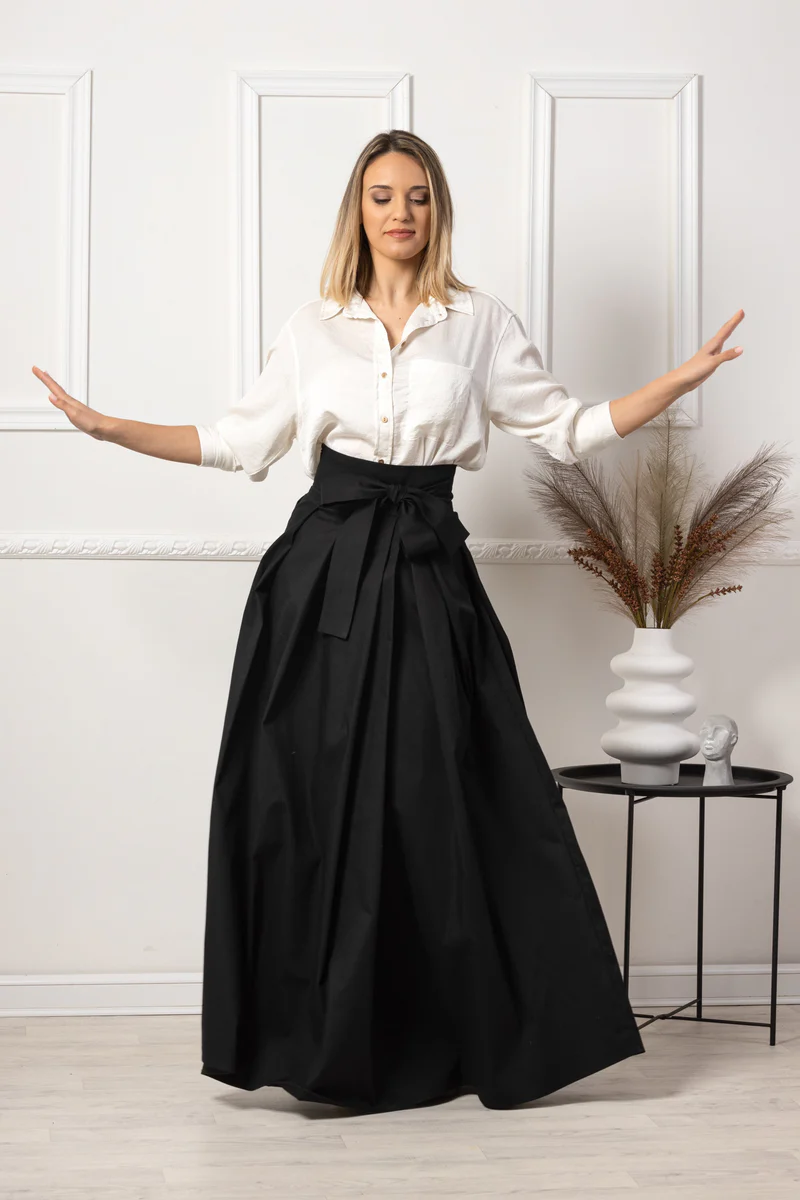 Pleated black maxi skirt styled with blouse.