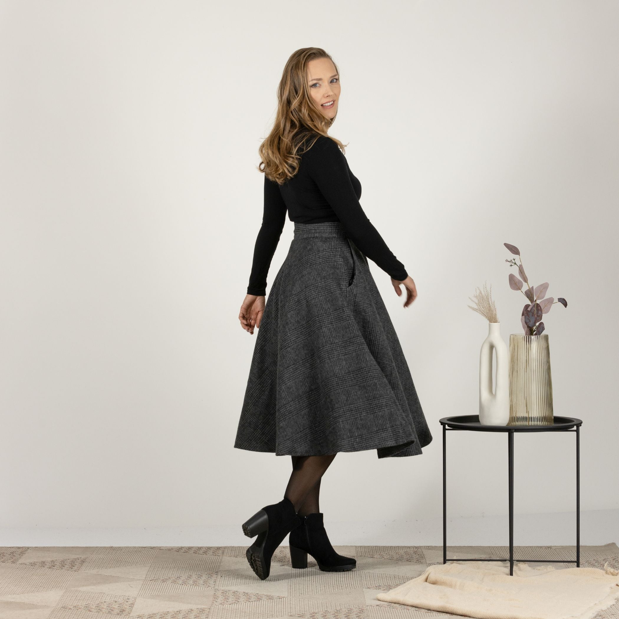 Side view of the Gray Plaid High Waisted Wool Midi Skirt in motion, showcasing the fluid movement and classic plaid style.