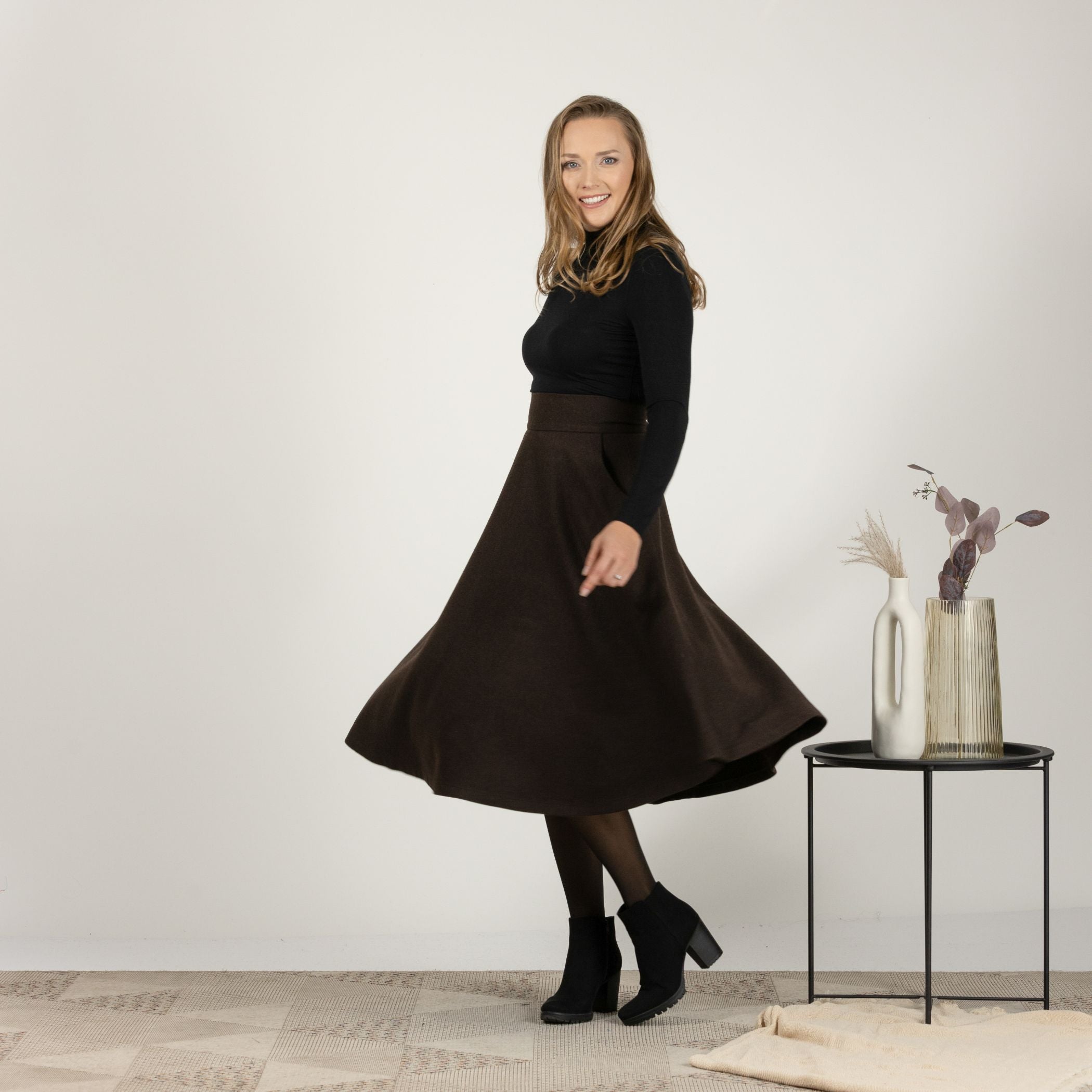 Side view of the Brown High Waisted Wool Midi Skirt in motion, showcasing the fluid movement and classic plaid style.