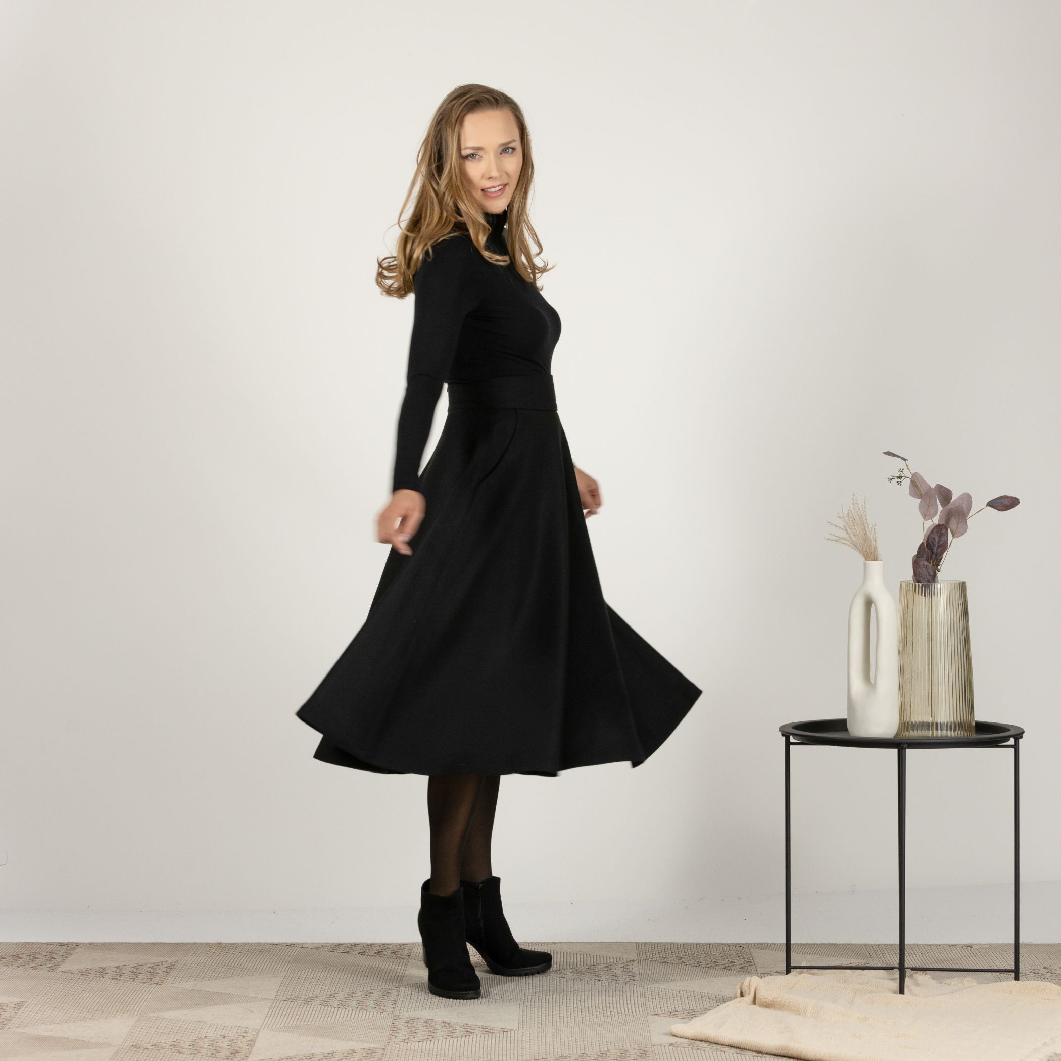 Side profile of the Black High Waisted Wool Midi Skirt, highlighting the high waist and the elegant silhouette of the skirt.