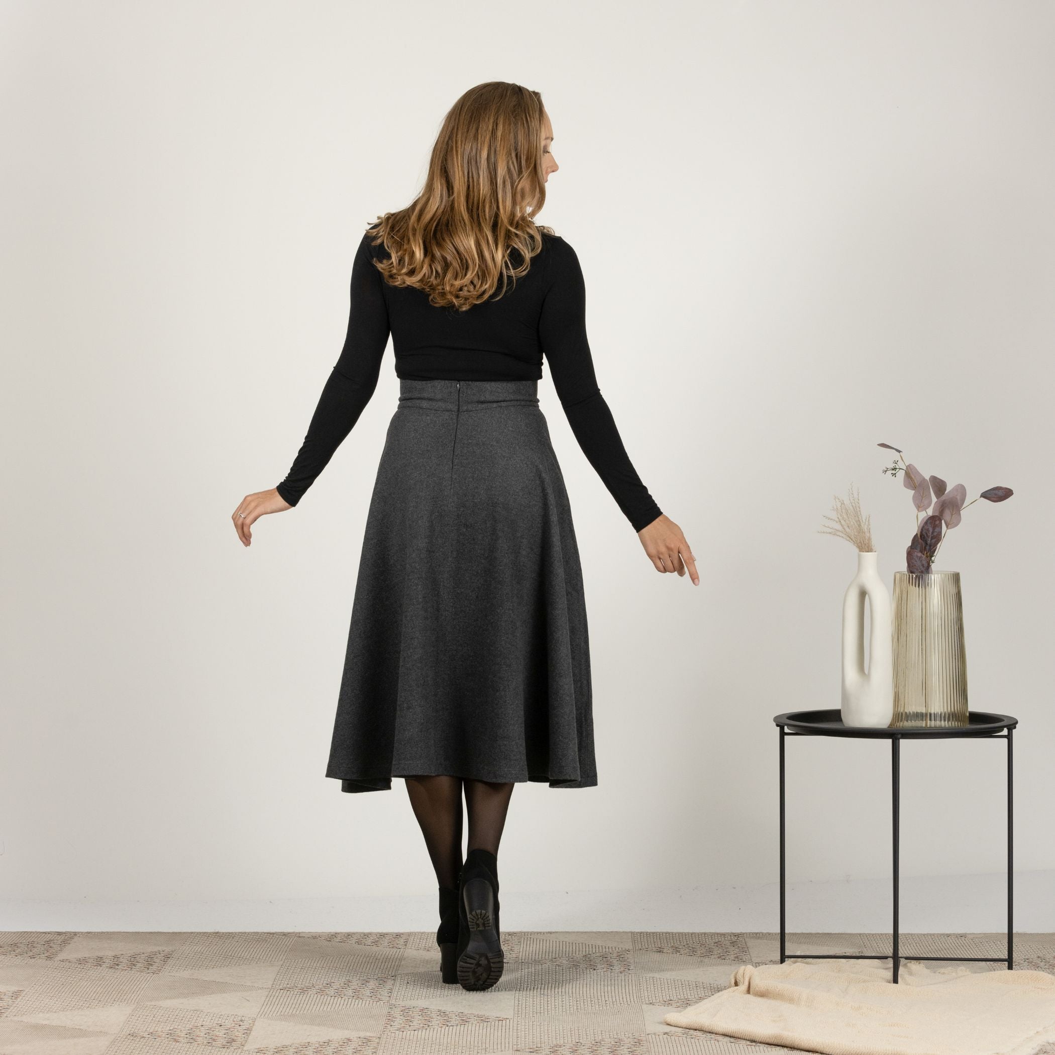 Back view of the Dark Gray High Waisted Wool Midi Skirt, showcasing the smooth drape and sophisticated design.