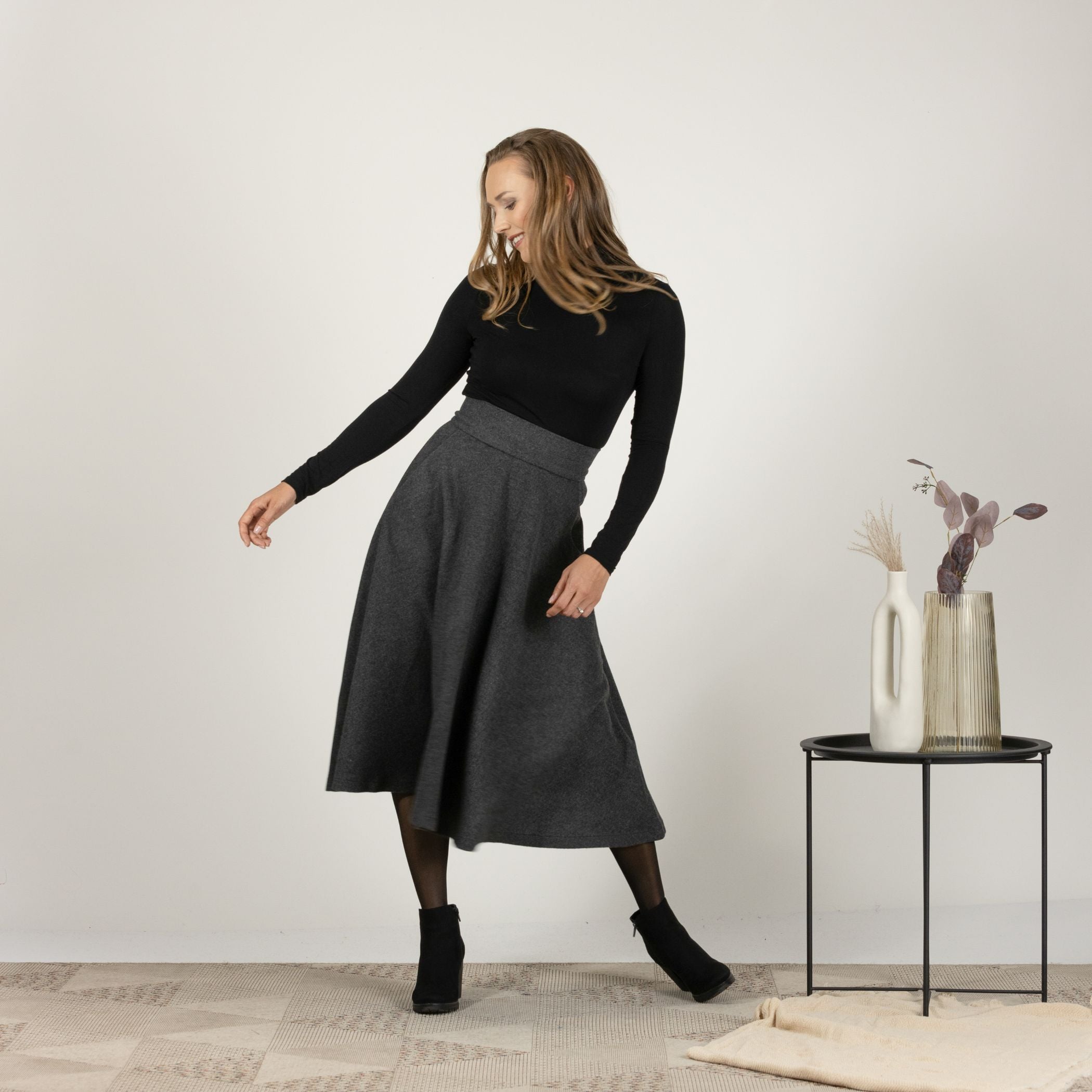 Front view of the Dark Gray High Waisted Wool Midi Skirt, emphasizing the defined waist and the sleek, elegant drape.