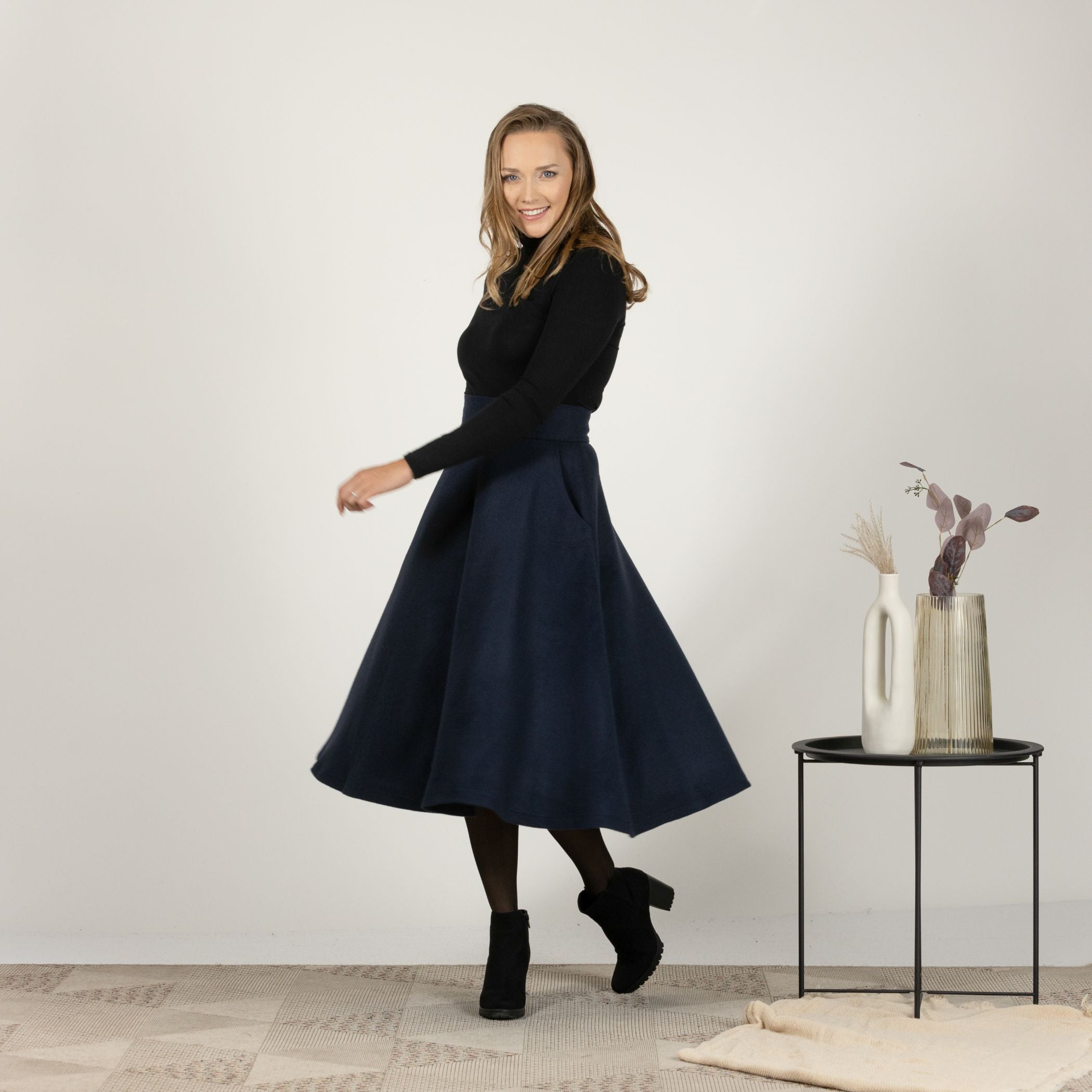 Side profile of the Dark Blue High Waisted Wool Midi Skirt, highlighting the high waist and the elegant silhouette of the skirt.