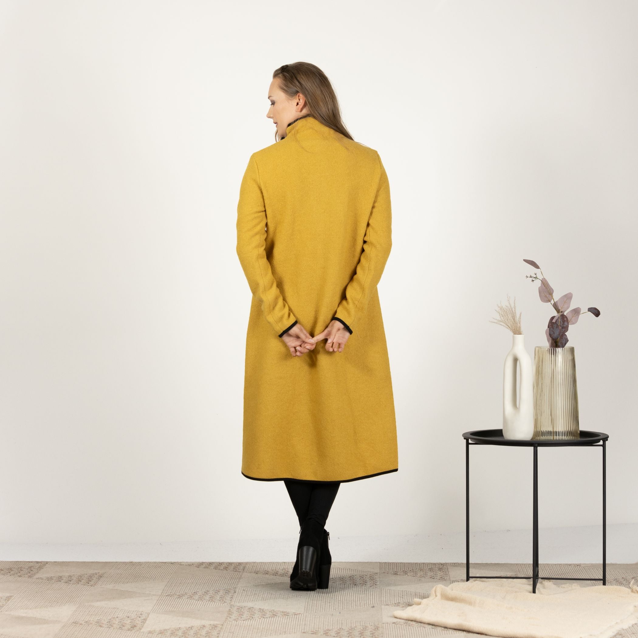 Back view of the Mustard Boiled Wool Coat with Pockets, emphasizing the clean lines and seamless design for a timeless look.