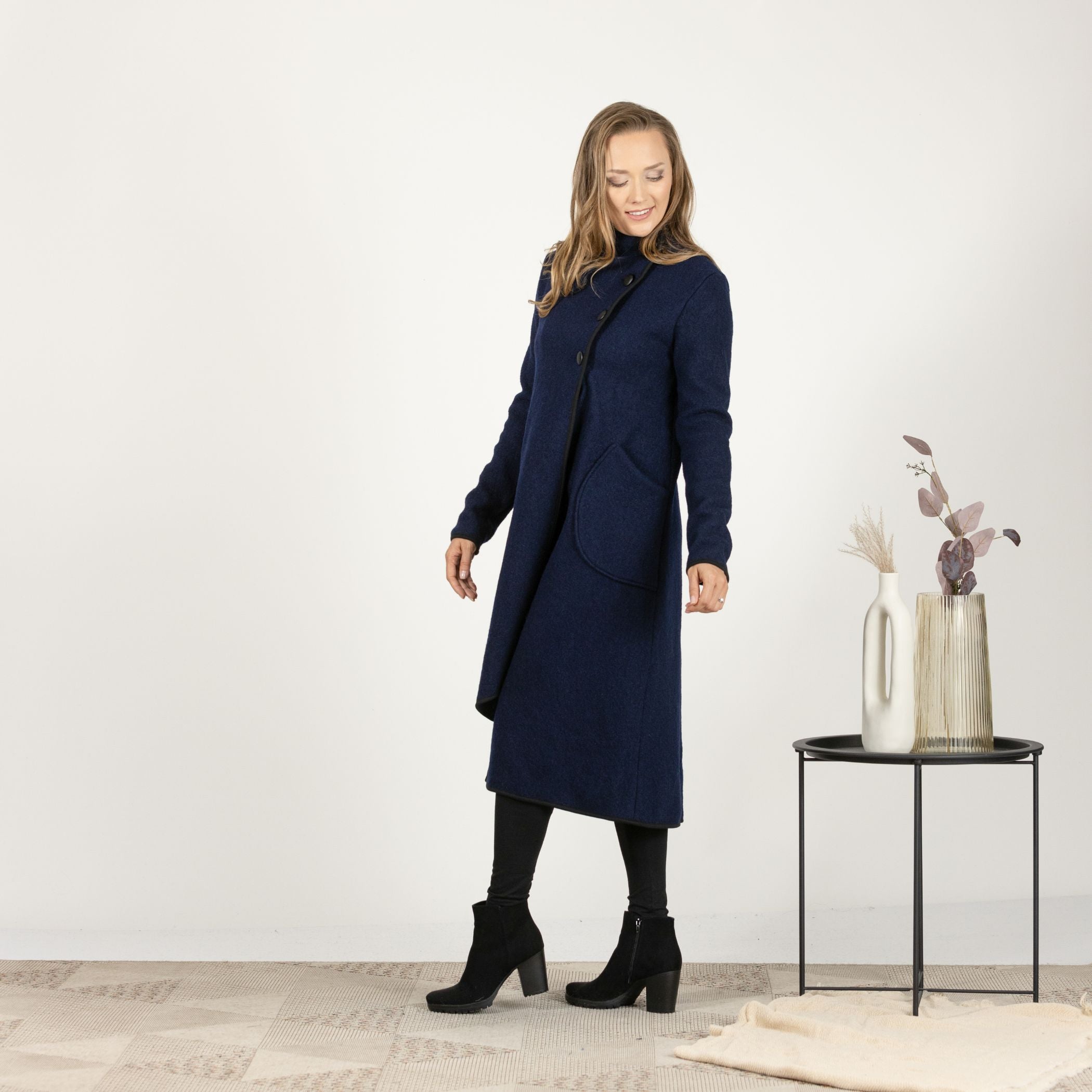 Side view of the Dark Blue Boiled Wool Coat with Pockets, showing the elegant drape of the wool fabric and the functional large pockets.