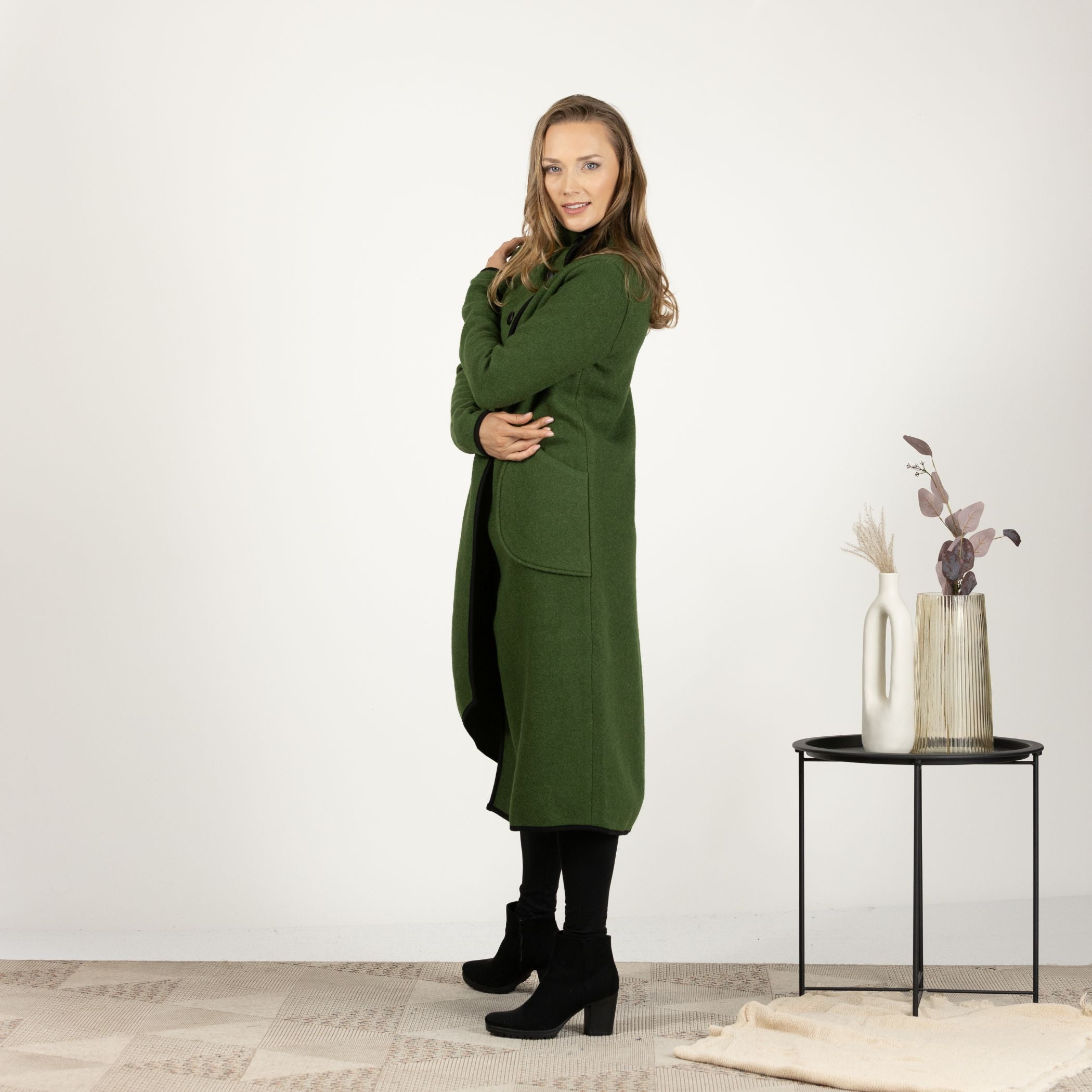 Side view of the Forest Green Boiled Wool Coat with Pockets in motion, showcasing the fluid movement and warmth of the wool material.