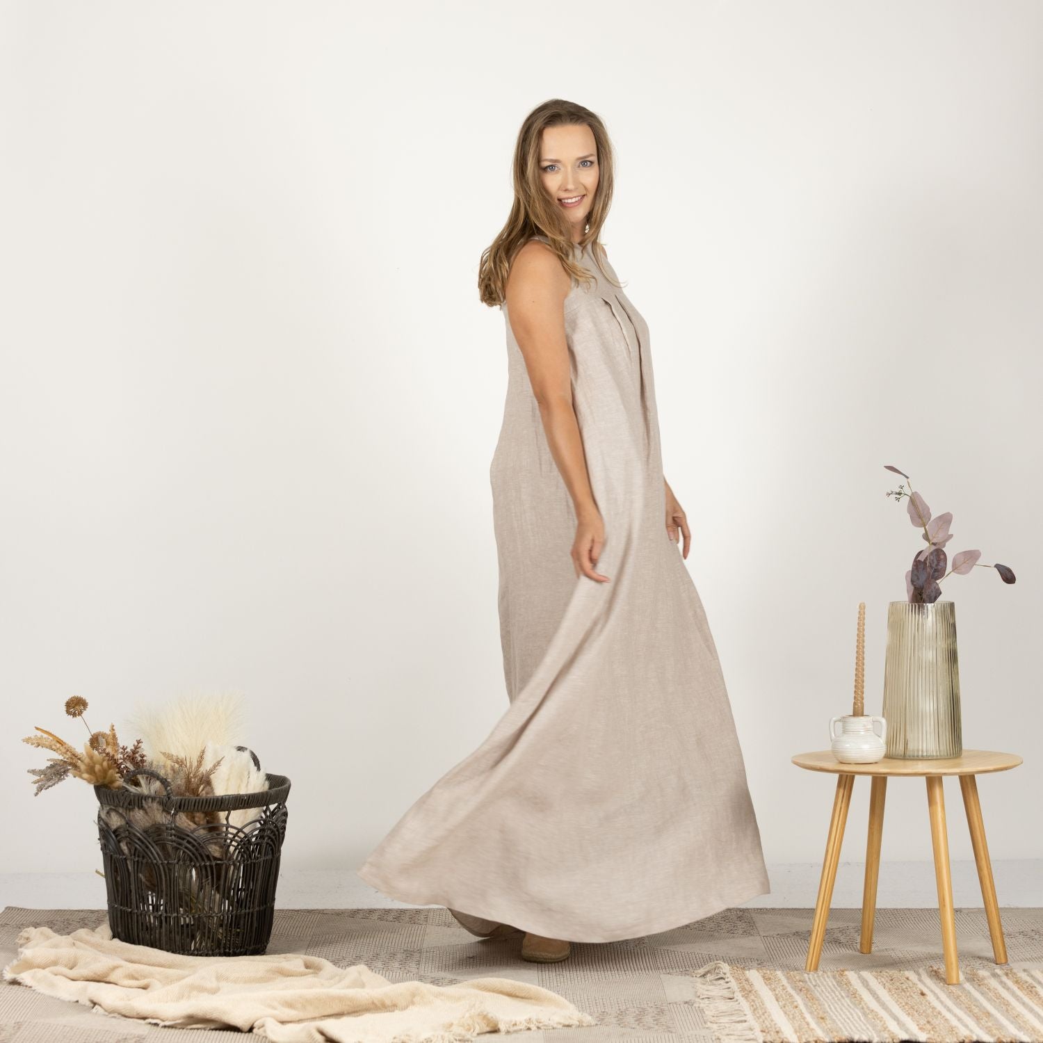 Side view of the Loose Linen Maxi Dress in Natural, showcasing its flattering drape and functional side pockets for added convenience.