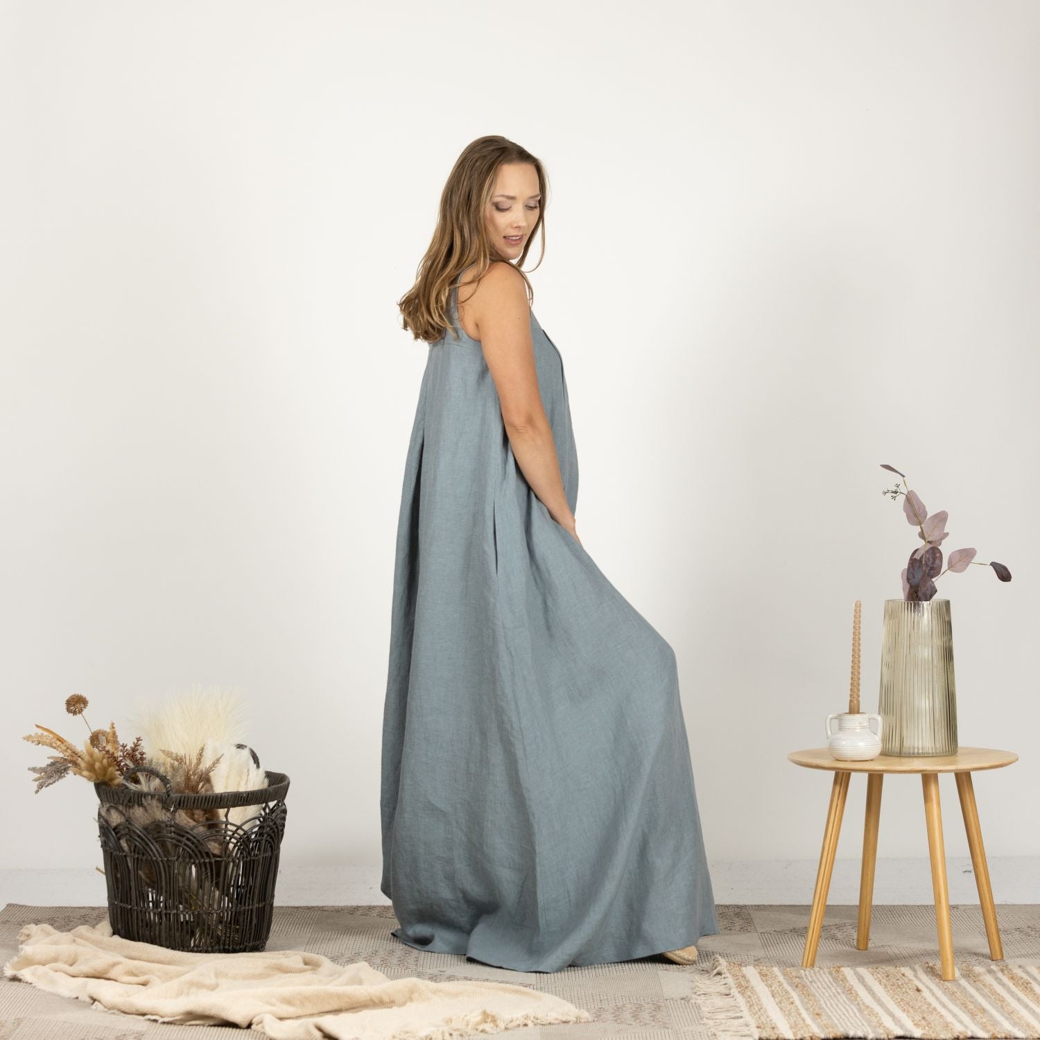 Side view of the Loose Linen Maxi Dress in Dusty Blue, showcasing its flattering drape and functional side pockets for added convenience.