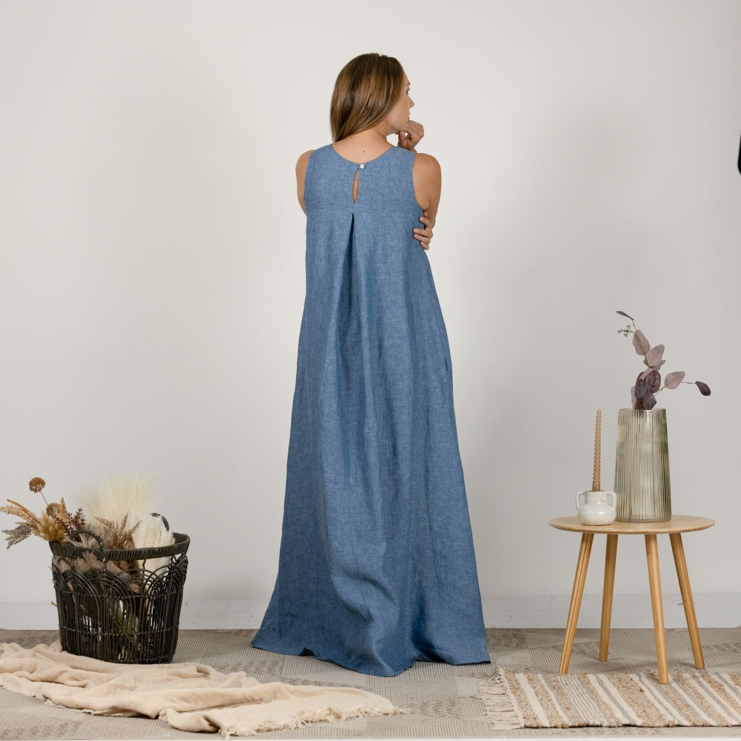 Back view of the Loose Linen Maxi Dress in Blue Melange, highlighting the seamless design and flowing trapeze silhouette.