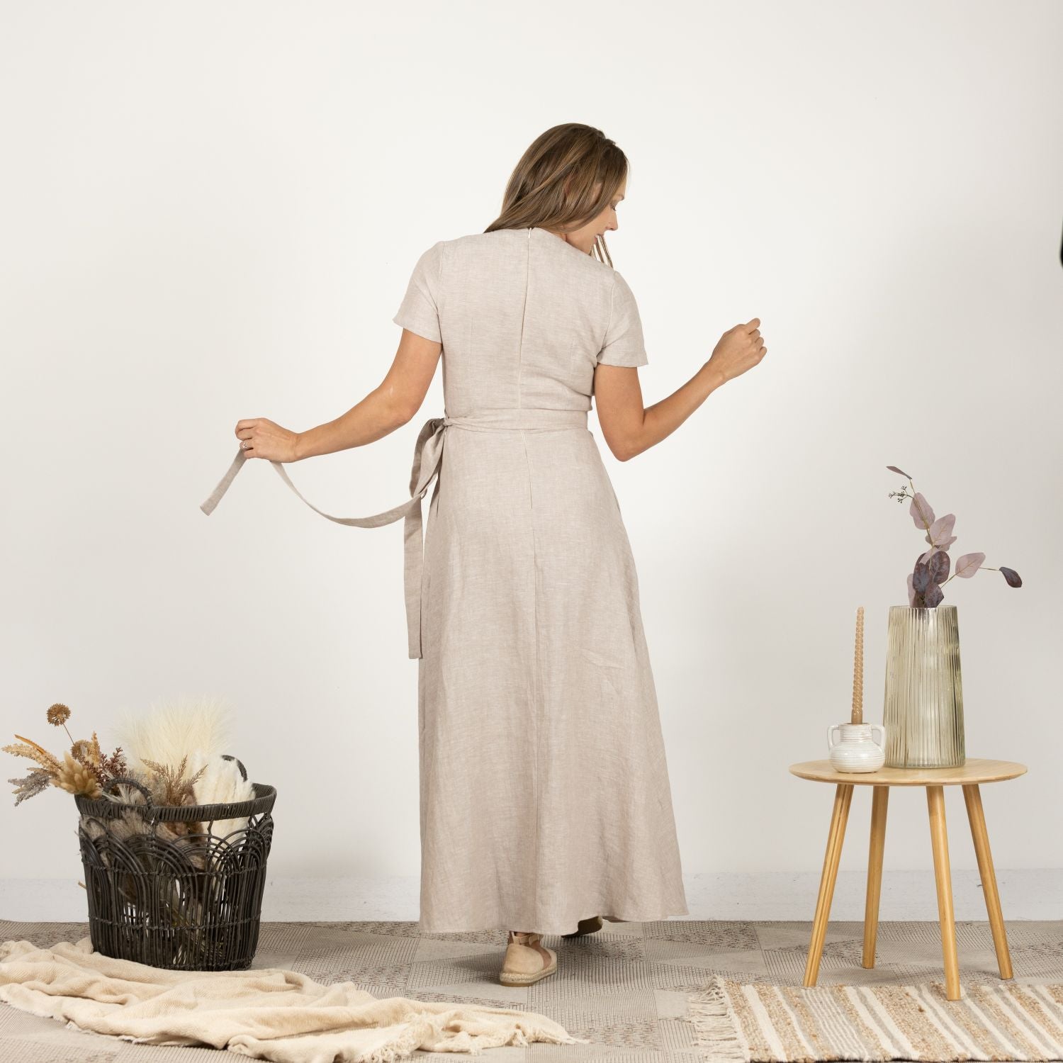 Rear perspective of the Linen Wrap Around Dress with Waist Tie on model, highlighting the dress's graceful flow and simple elegance.