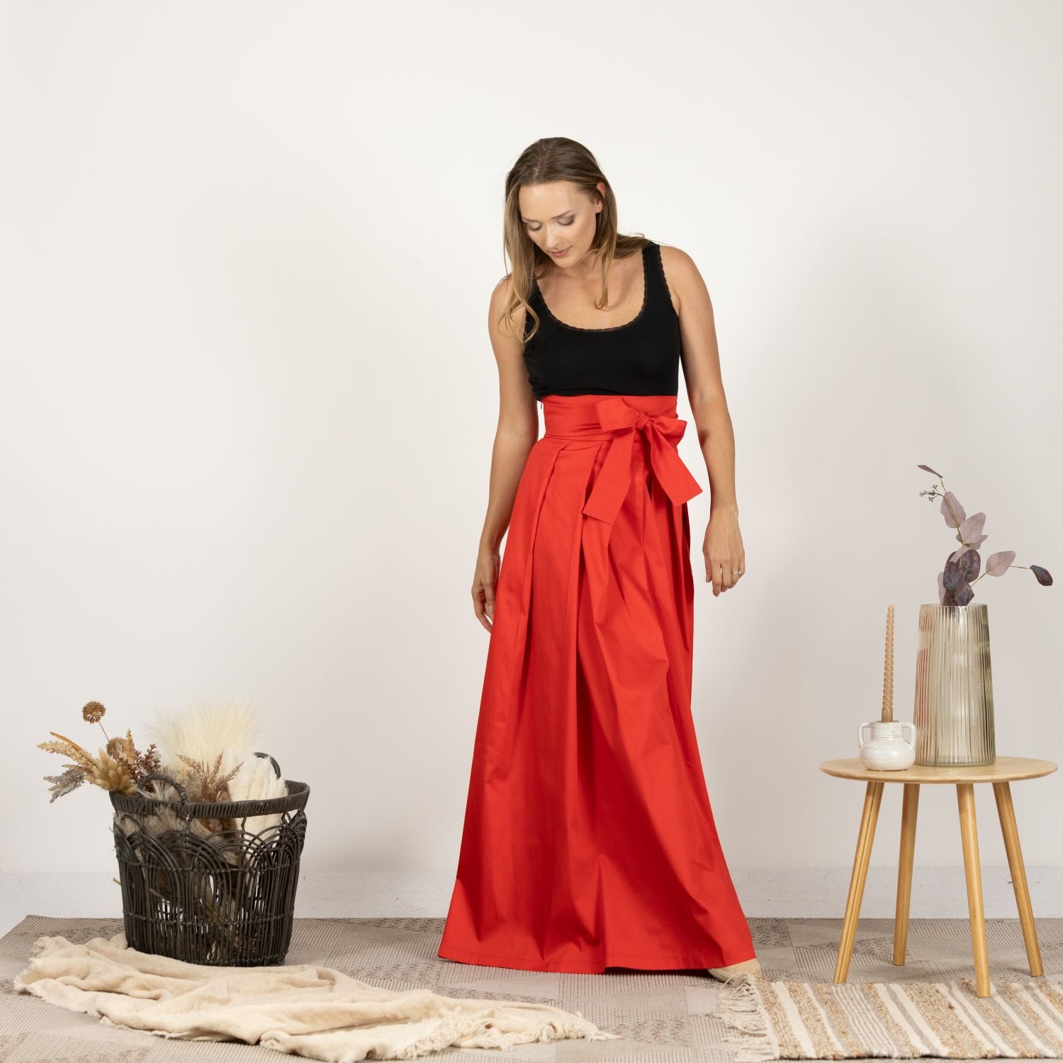 Full-length front view of the High Waist Pleated Maxi Skirt in Red, displaying the flowing maxi length and the chic high waist.