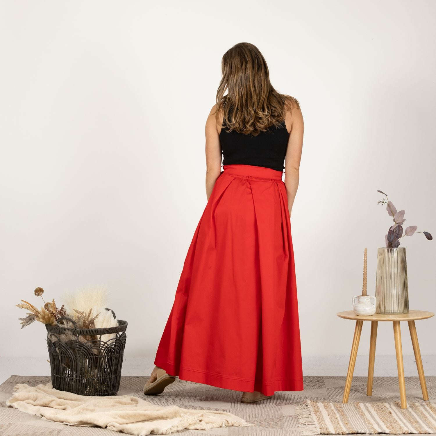 Back view of model in the Cascading Cotton Skirt with Pockets, showing the skirt's full length and elegant drape.