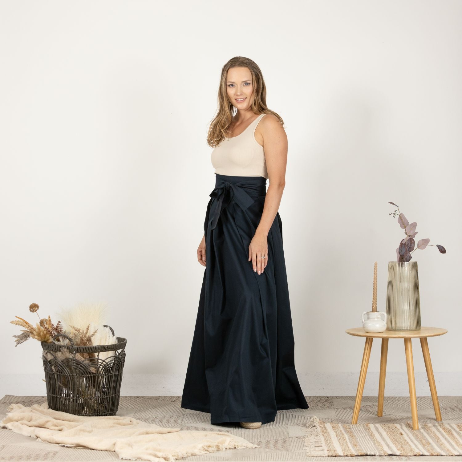 Side view of the High Waist Pleated Maxi Skirt in Dark Blue, highlighting the fluid movement of the fabric and the sophisticated maxi length.