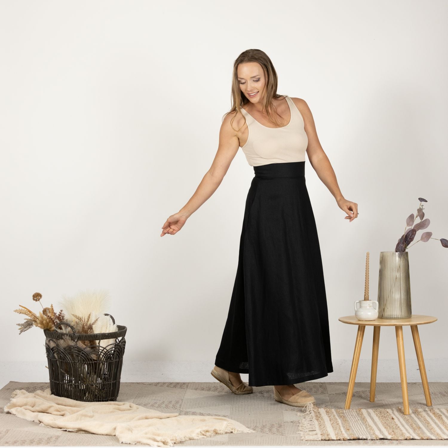 Front view of the Black Minimalist High Waist Linen Maxi Skirt paired with a tucked-in blouse, showcasing a sophisticated look perfect for the office or formal events.