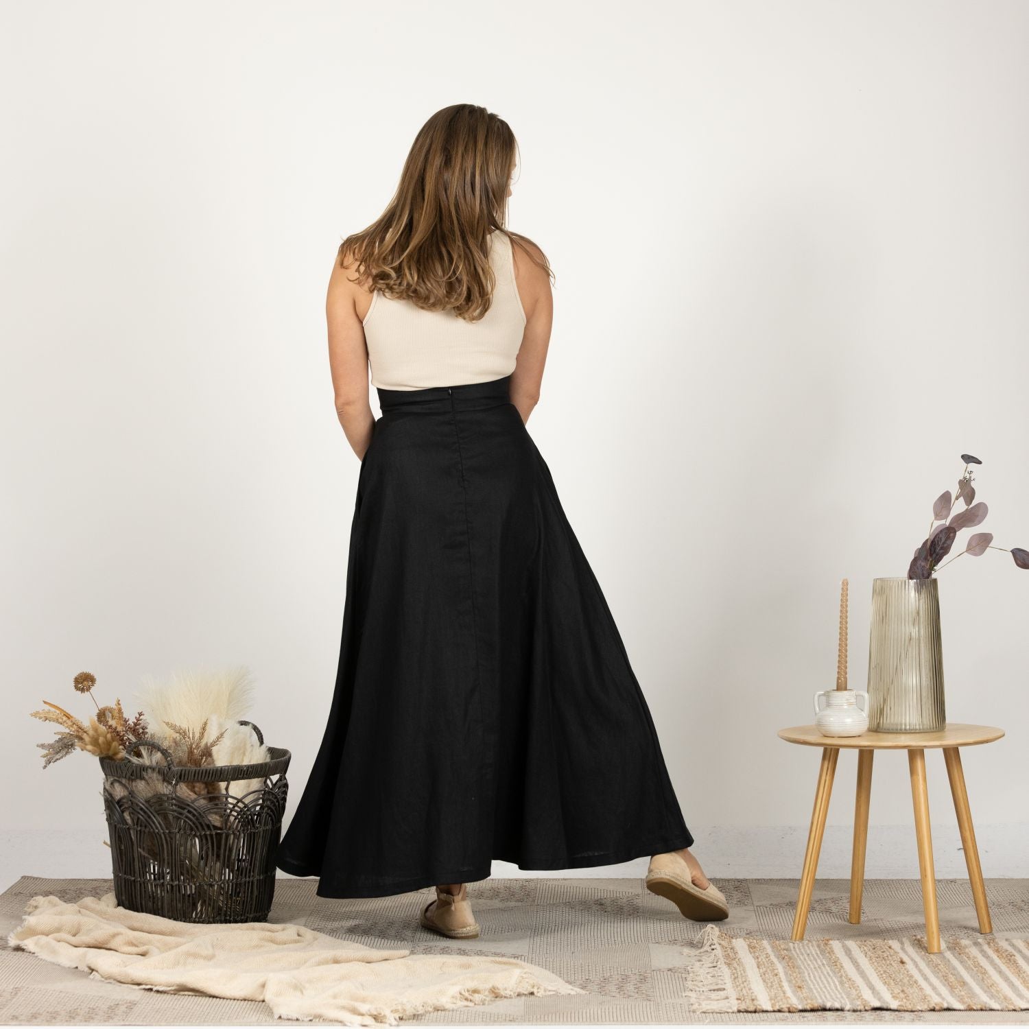 Back view of the Black Minimalist High Waist Linen Maxi Skirt, highlighting the smooth, seamless design and the elegant flow of the maxi-length linen fabric.