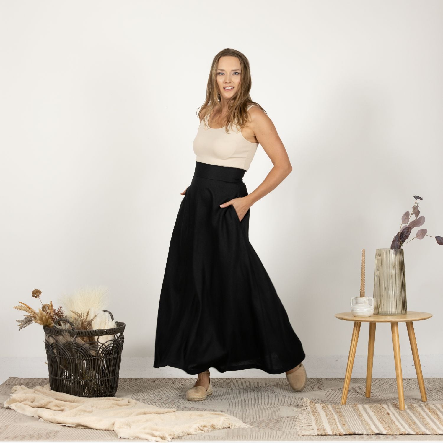 Front view of the Black Minimalist High Waist Linen Maxi Skirt in motion, displaying the fluid movement of the lightweight linen fabric.