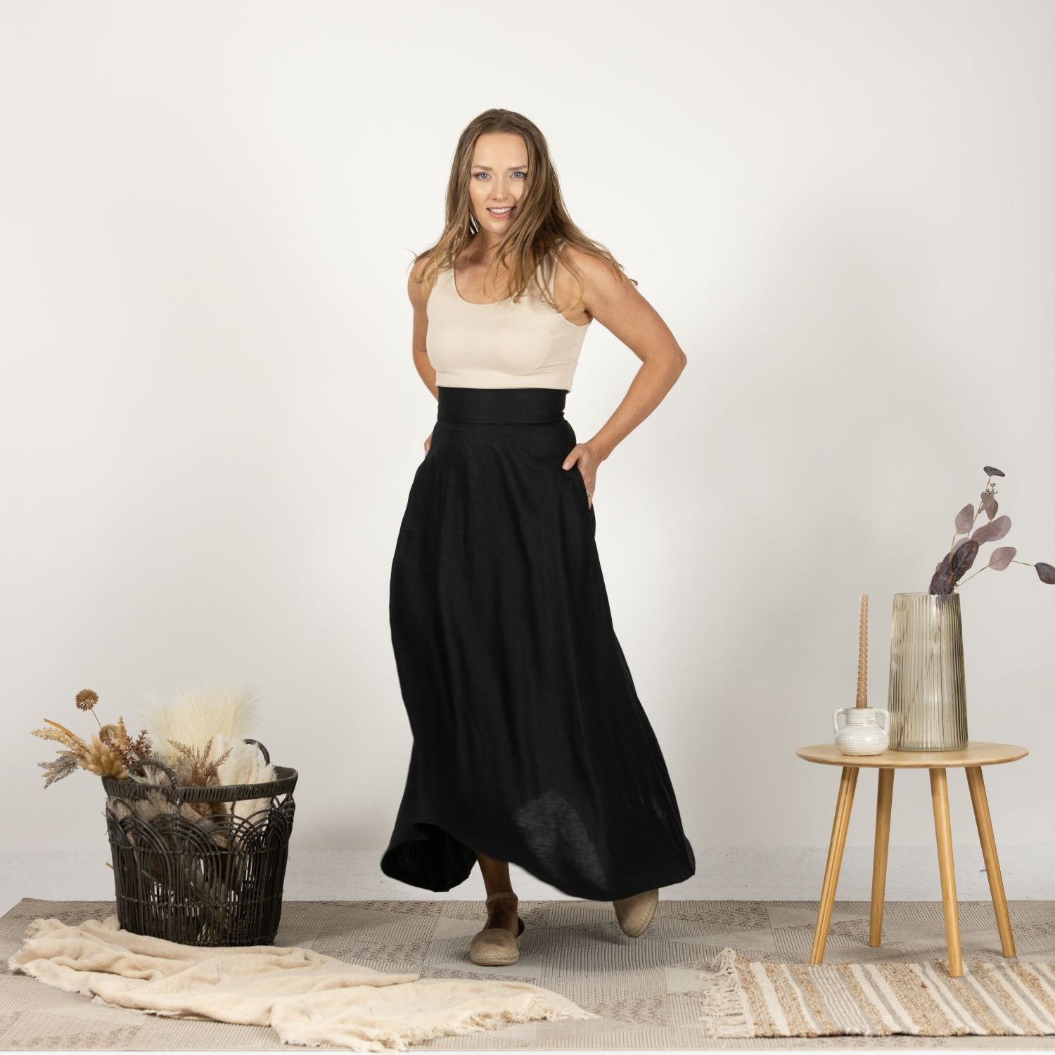 Front view of the Black Minimalist High Waist Linen Maxi Skirt styled with a tank top and sandals, demonstrating a relaxed and comfortable outfit ideal for warm weather.